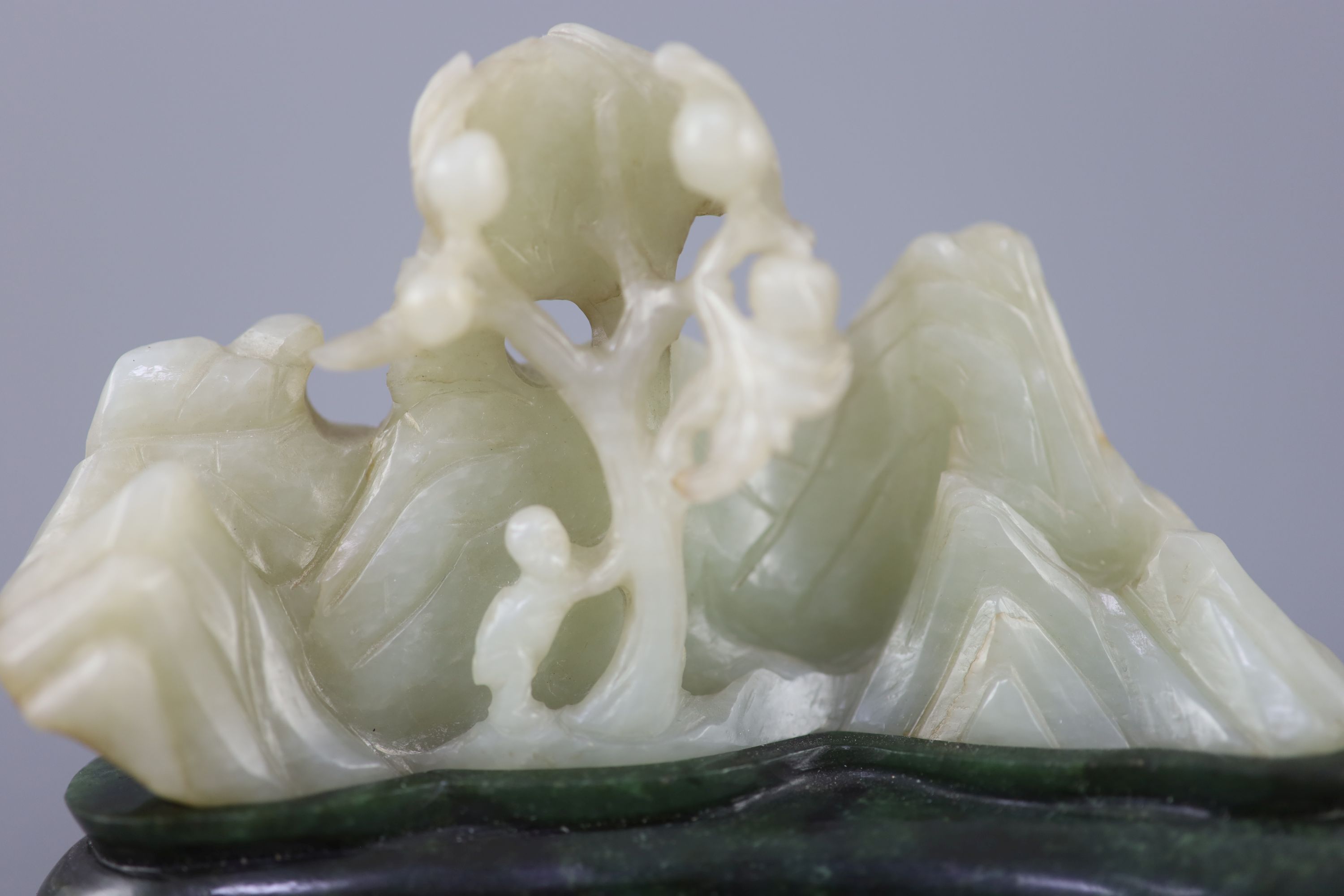 A Chinese pale celadon jade boulder carving, Qing dynasty, 13cm wide, the spinach green jade stand probably later